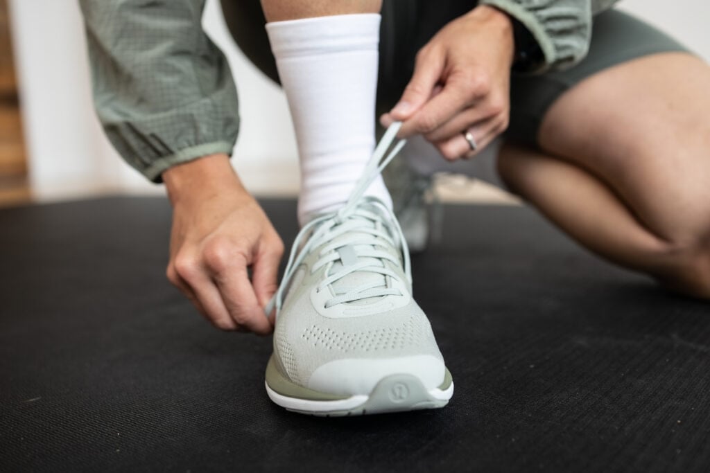 woman tying laces of her training shoes