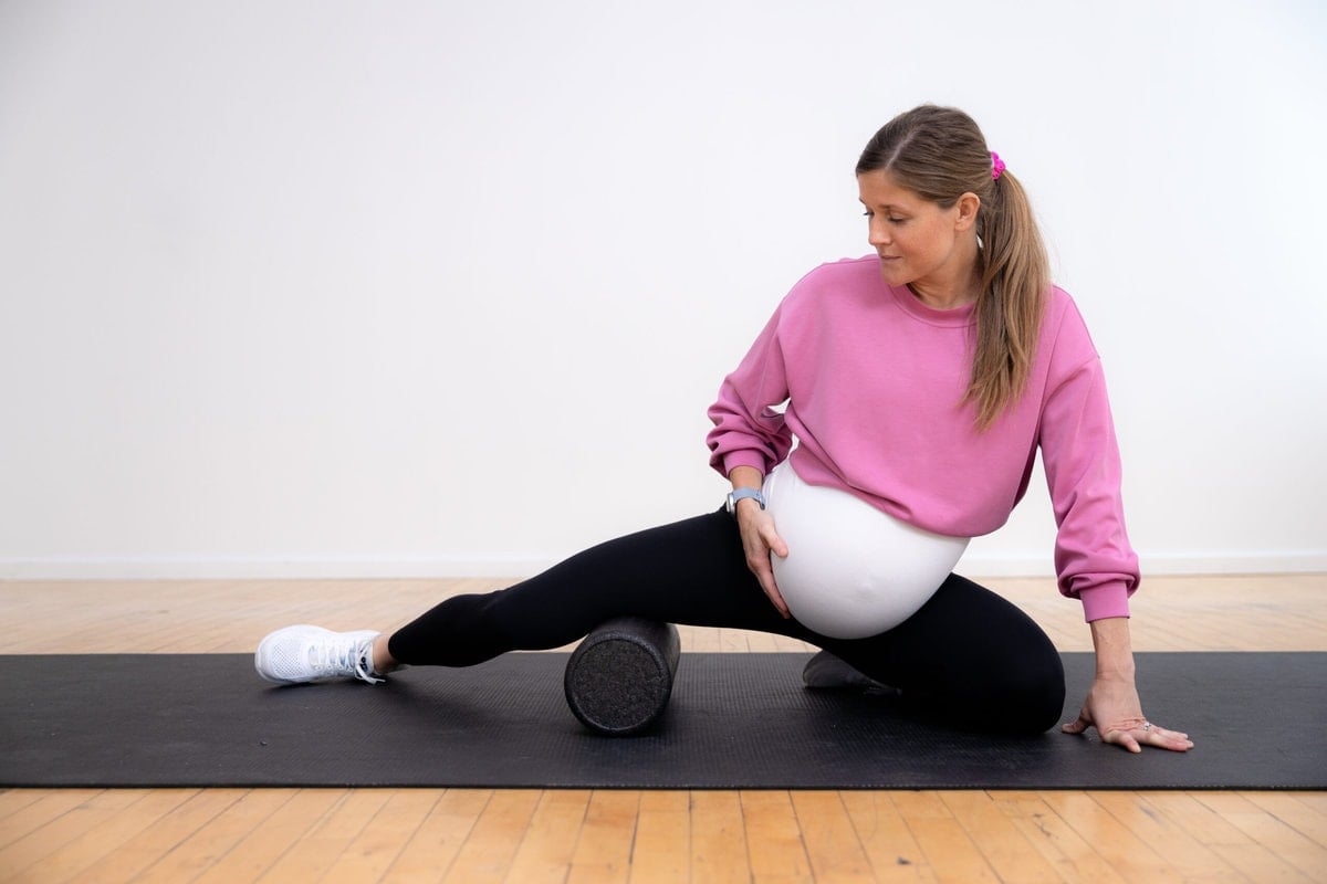 pregnant woman stretching on foam roller to reduce pelvic pain during pregnancy