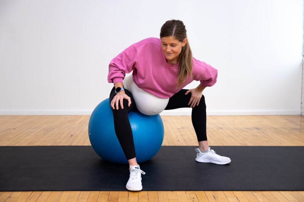 pregnant woman sitting on an exercise ball lengthening adductor muscles to reduce pelvic pain during pregnancy
