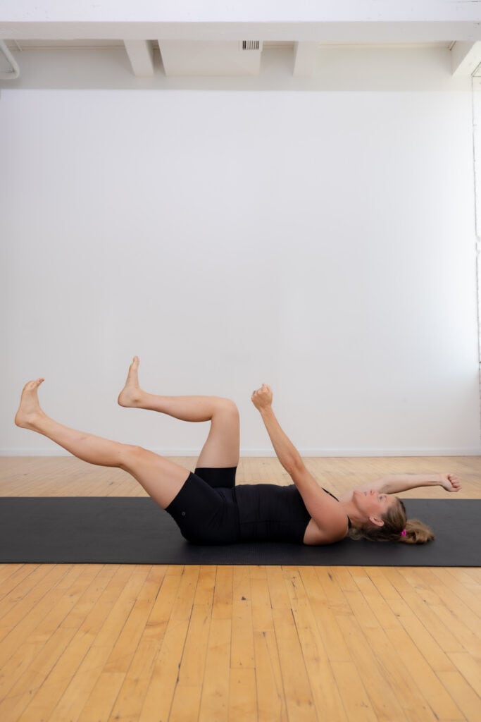 postpartum woman performing a beginner dead bug exercise to rebuild core strength