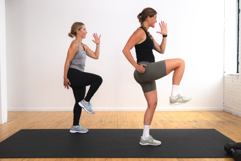 two women performing a knee drive to target the glutes as part of beginner leg workout