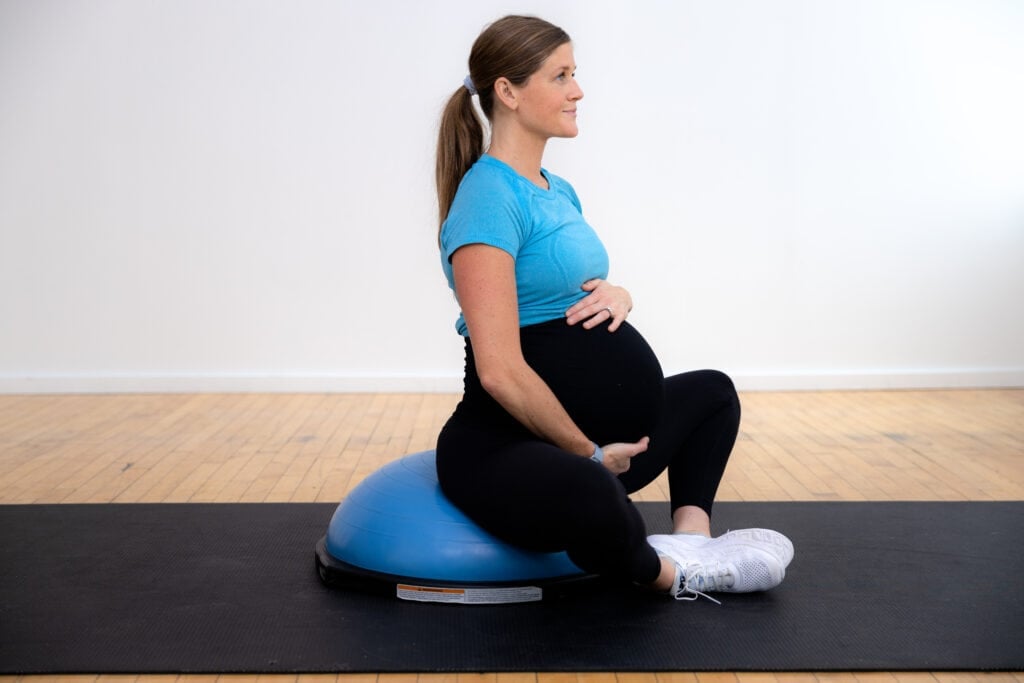 pregnant woman performing a butterfly stretch on a bosu ball