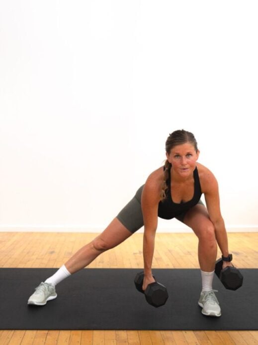 woman performing a lateral squat with a dumbbell