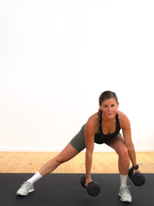 woman performing a lateral squat with a dumbbell
