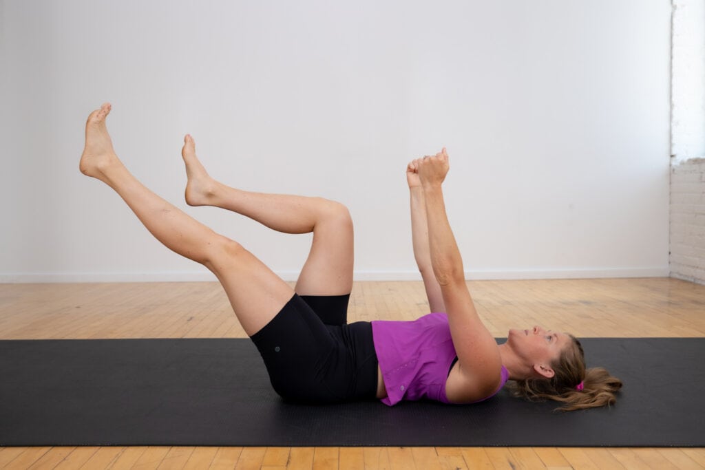 postpartum woman performing a modified deadbug exercise on her back