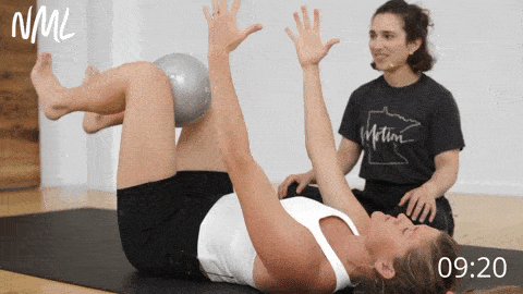 woman performing a dead bug exercise as part of beginner pilates workout