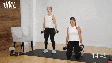 two women performing a kneeling hammer curl and neutral shoulder press
