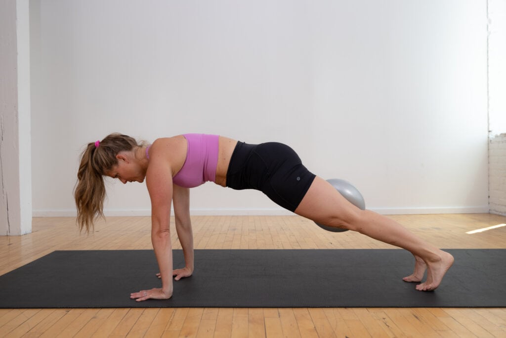 woman performing a high plank as part of pilates ab workout