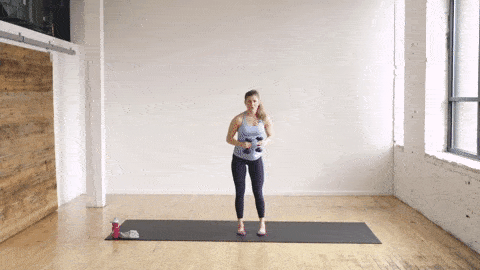 pregnant woman performing a curtsy lunge and crossbody punch in a barre class workout at home