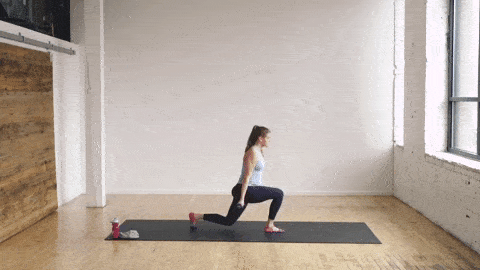 pregnant woman performing a lunge and bicep curl in a barre class workout at home
