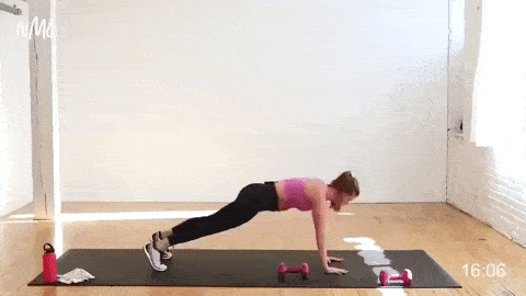 woman performing a push up and army crawl with a dumbbell pass
