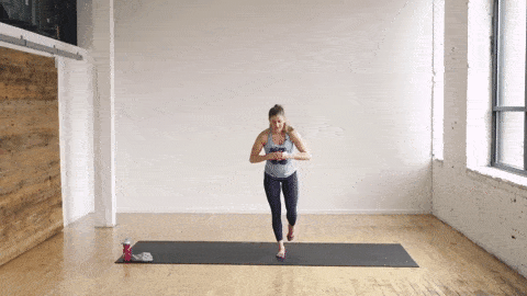 pregnant woman performing a single leg deadlift and airplane pose in a barre class workout at home