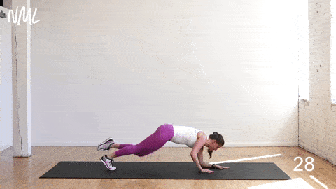 woman performing a staggered plank kick through in an advanced ab workout for women