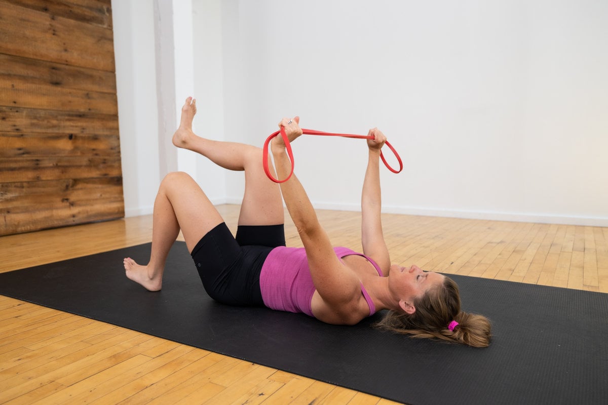 postpartum woman lying on her back performing diastasis recti postpartum ab exercises