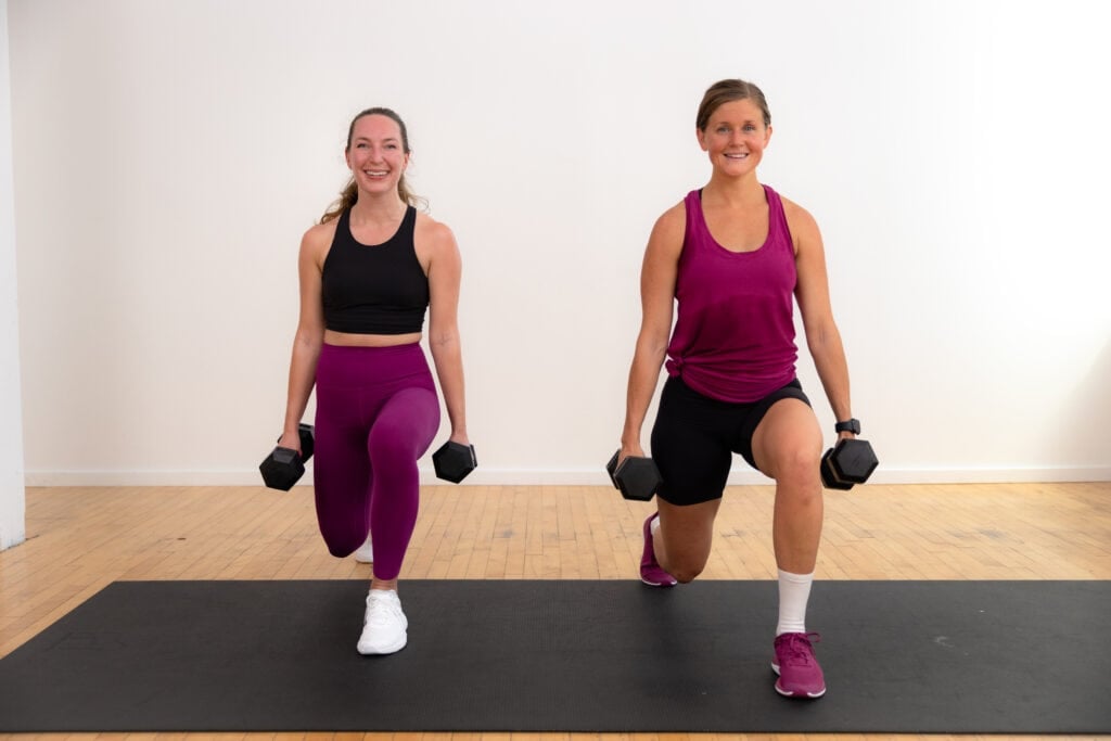 Two women performing a front lunge as part of a full body strength pyramid workout