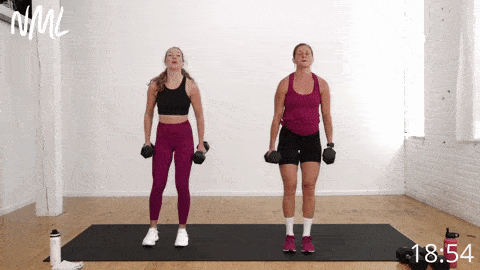 two women performing reverse lunges and hammer curls as part of pyramid workout