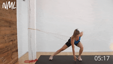 postpartum woman performing a banded lateral lunge to build glute and hip strength