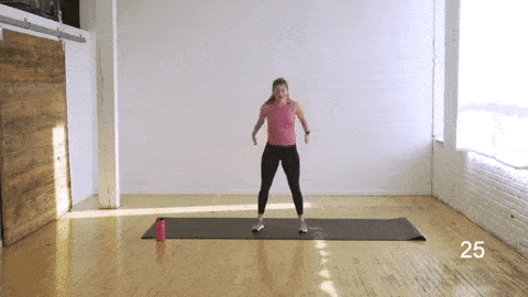 woman performing a 2-pulse air squat in an abs and butt workout