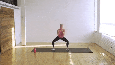 woman performing a 2-pulse sumo squat and alternating leg lift in an abs and butt workout