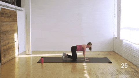 woman performing table top fire hydrant kicks in an abs and butt workout
