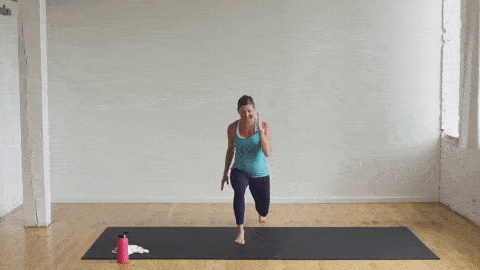 pregnant woman performing a knee drive and lunge pulse in a cardio barre workout
