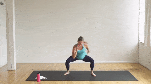 pregnant woman performing a plie squat and side leg lift in a cardio barre workout