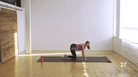 woman performing a table top side leg lift and front to back oblique crunch in an abs and butt workout