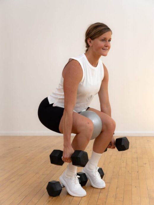 woman performing a heels elevated squat inner thigh workout