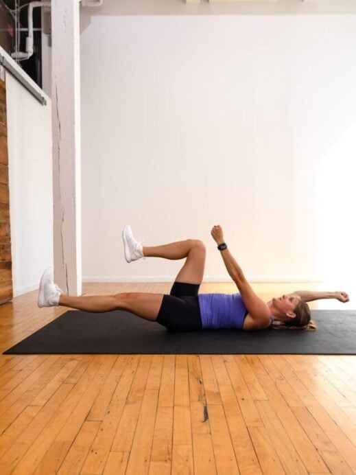woman lying on her back performing a dead bug exercise