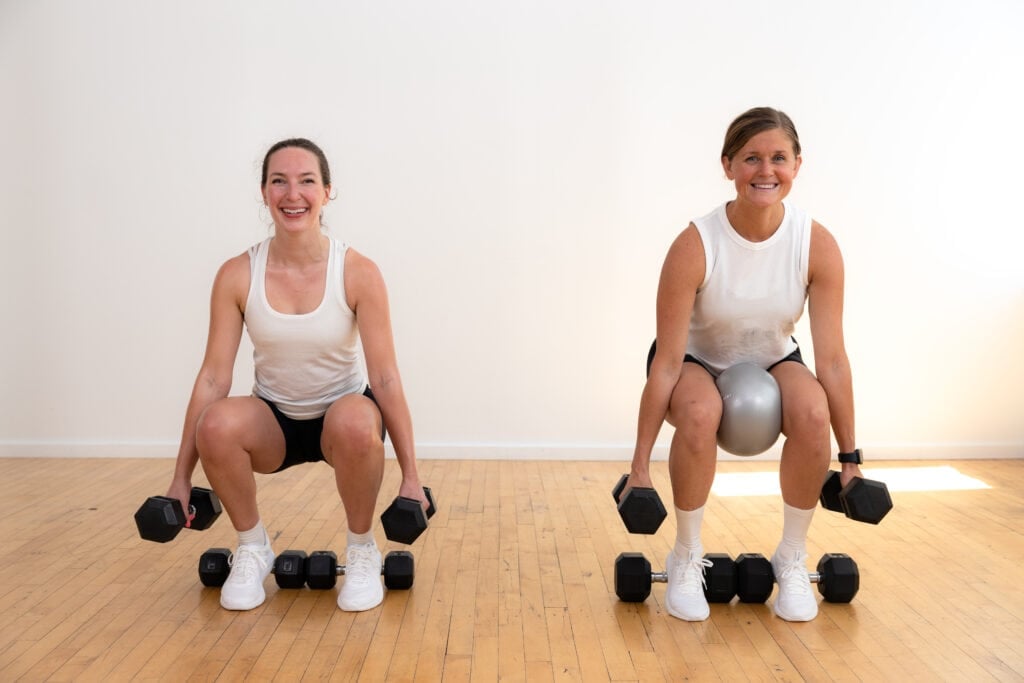 two women performing a heels elevated squat as part of inner thigh workout