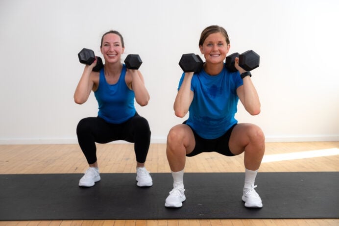 two women performing a front squat with dumbbells as part of weight training for women workout
