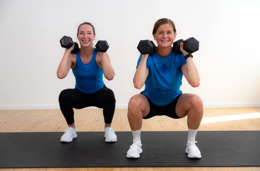 two women performing a front squat with dumbbells as part of weight training for women workout