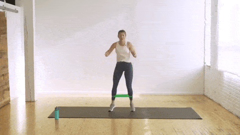 woman performing banded quarter turn jumps with a resistance band
