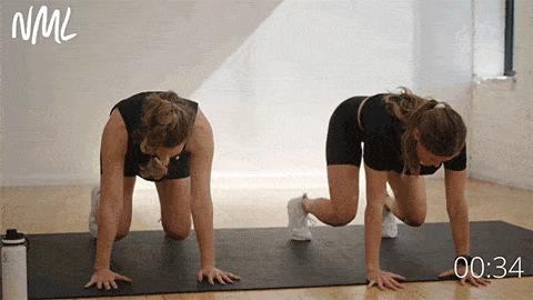 two women demonstrating how to perform a bear crawl exercise
