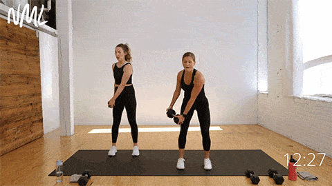 two women performing a diagonal lift as part of weighted core workout