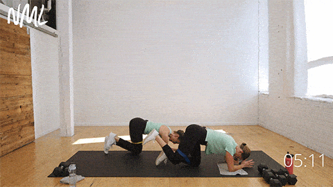 two women performing forearm donkey kicks as part of abs and glutes workout
