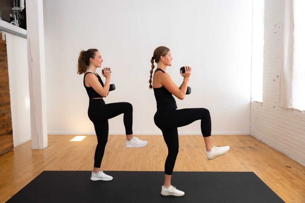 two women performing a goblet hold march as part of standing core workout with weights