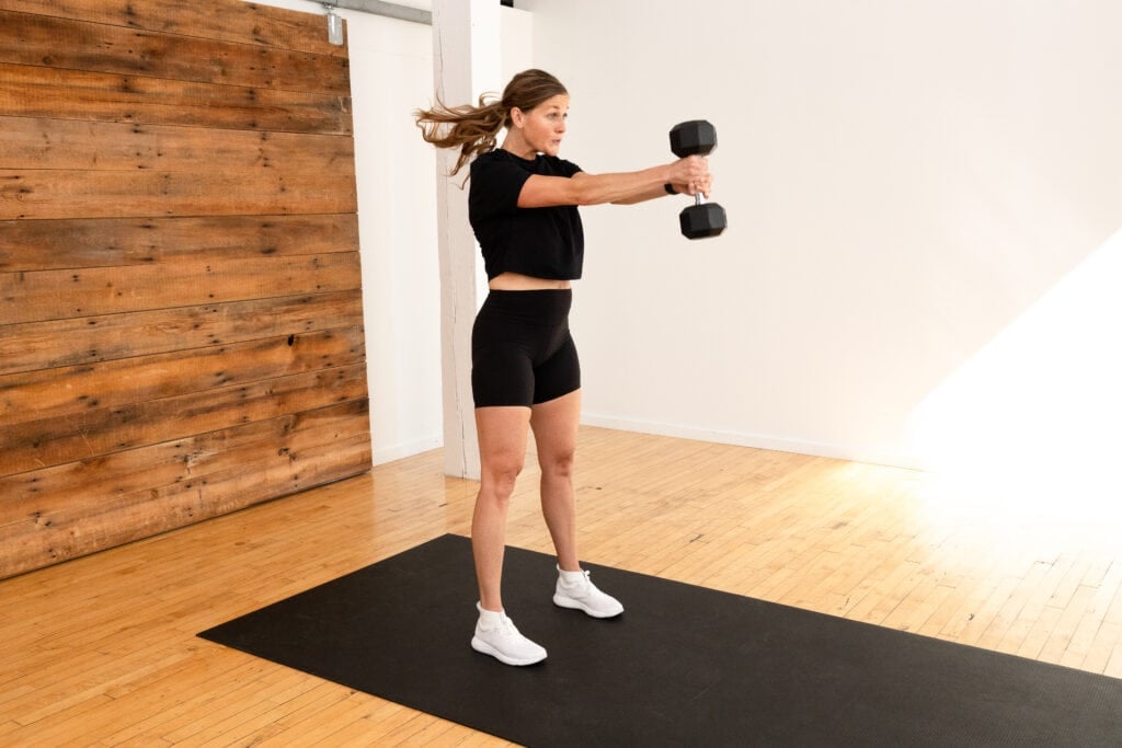 woman performing dumbbell swings to work hamstrings