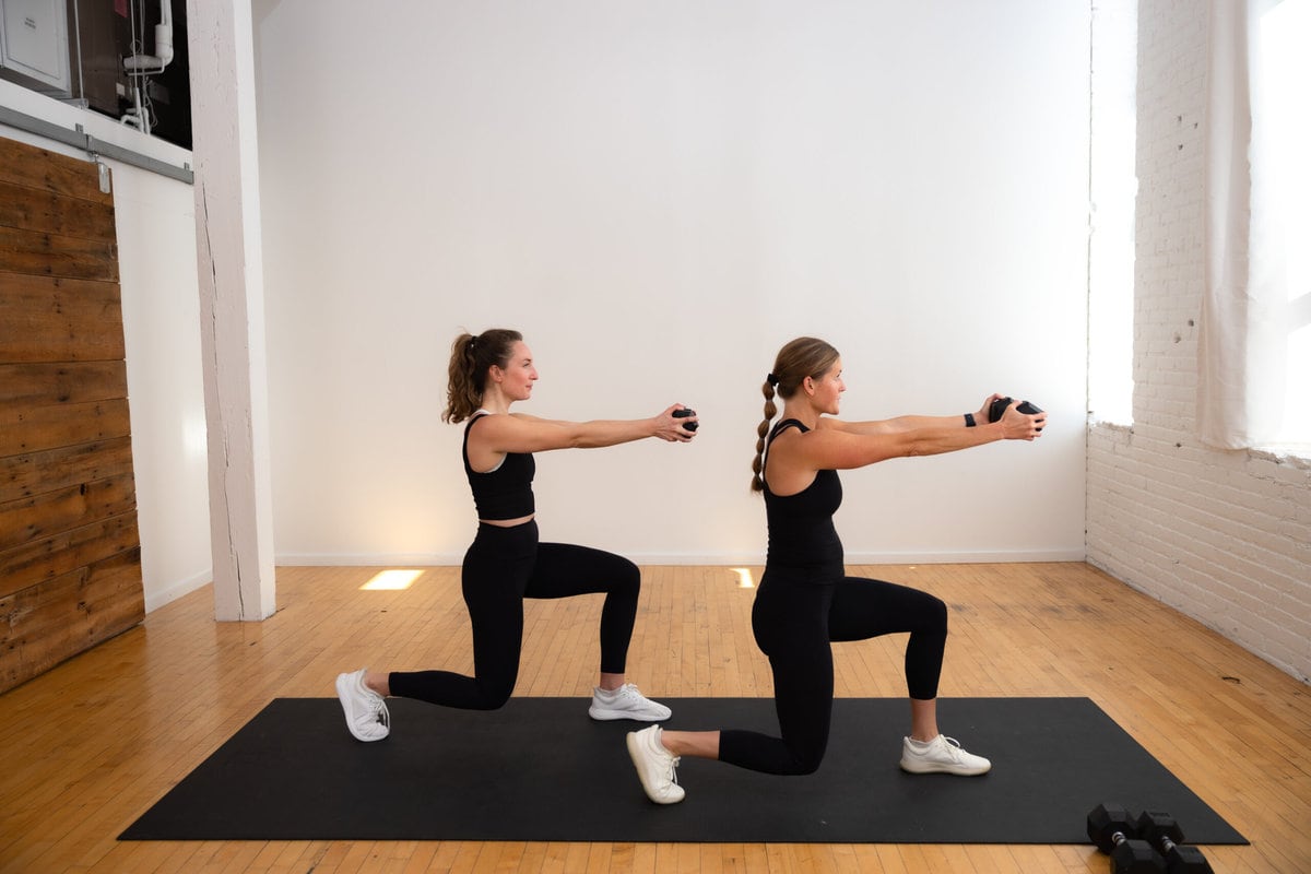 two women performing a lunge and dumbbell press out as part of core workouts with weights