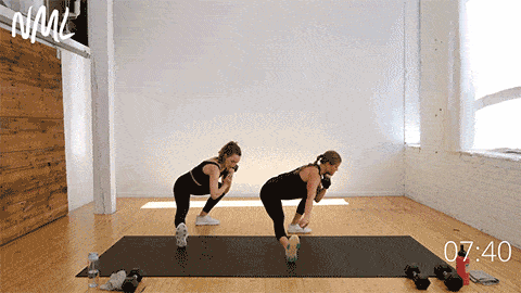 two women performing a cossack squat and shoulder press as part of standing core workout with weights