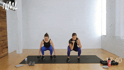 two women performing a staggered deadlift and squat clean as part of leg and back workout