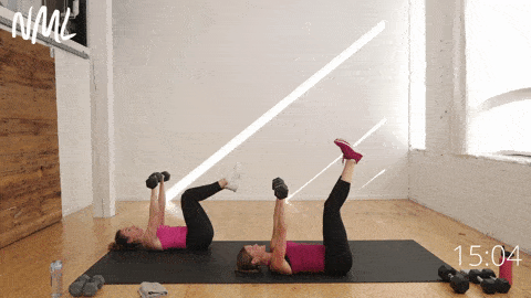 two women performing a dumbbell chest press from the floor and alternating leg lowers in a full body functional strength workout