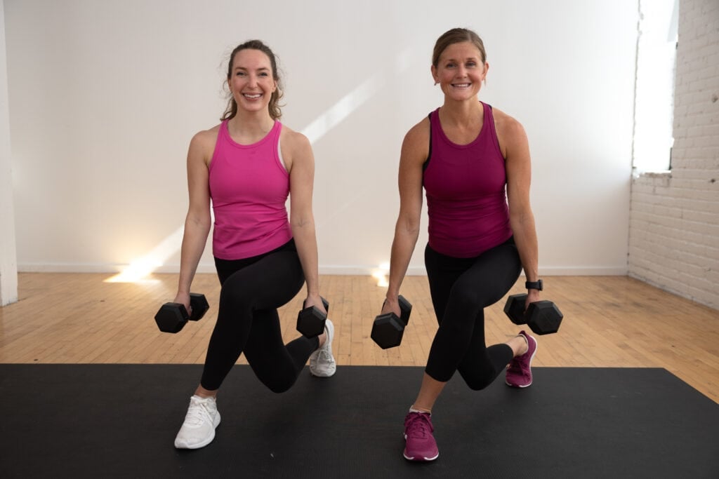 two women performing a curtsy lunge in a full body functional workout