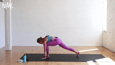 woman performing chaturanga to upward facing dog to downward facing dog in a yoga sculpt workout