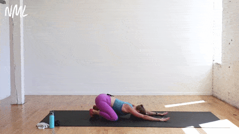 woman performing a high plank to child's pose sit back in a yoga sculpt workout