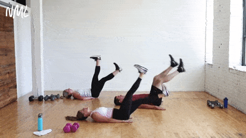 three people performing hollow rock scissor chops in a circuit training workout