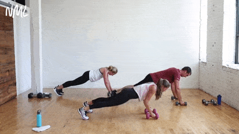 three people performing a push up and straight arm tricep kickback with a dumbbell in a circuit training workout