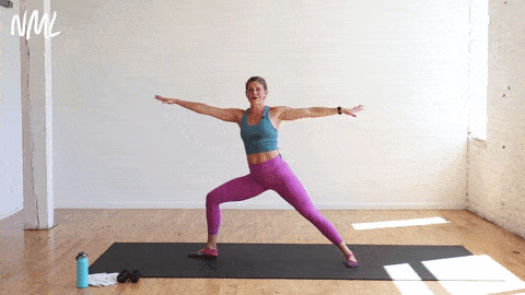 woman performing warrior two to a half wrap in a yoga sculpt workout
