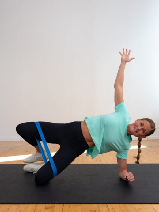 woman performing a clamshell exercise in an abs and glutes workout