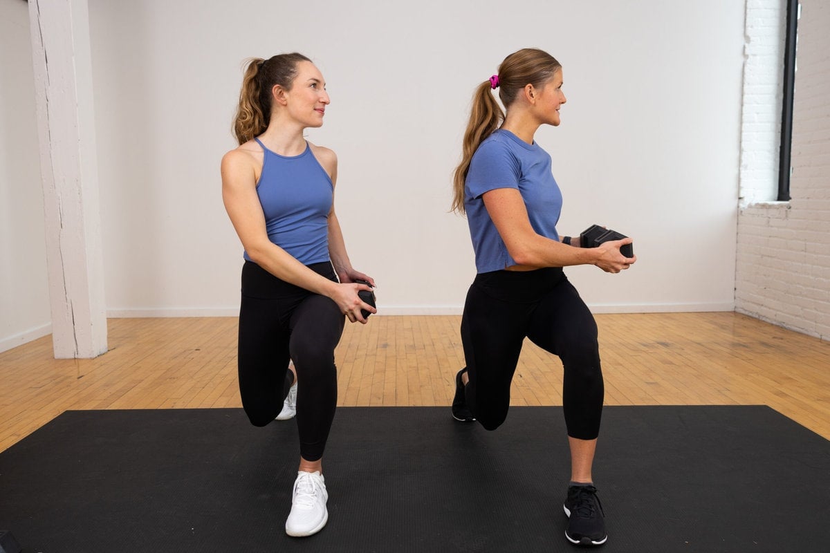 two women showing a lunge and rotation as part of functional core training workout